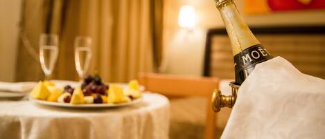 A bottle of Moët champagne on a table with a plate of fruit and two glasses.