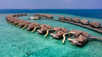Overwater bungalows connected by walkways over turquoise waters.