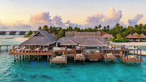 Overwater bungalows with thatched roofs, wooden walkways, and clear turquoise water. - Ozen Reserve Bolifushi- All Inclusive with Free Transfers (Bolifushi Island)