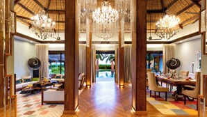 A spacious hotel lobby with a wooden floor, a dining area with a large table and chairs, and a view of a pool through an open doorway. - Ozen Reserve Bolifushi- All Inclusive with Free Transfers (Bolifushi Island)