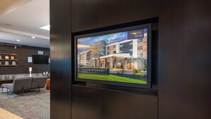 A television displaying a Courtyard by Marriott hotel with a view of the building's exterior.