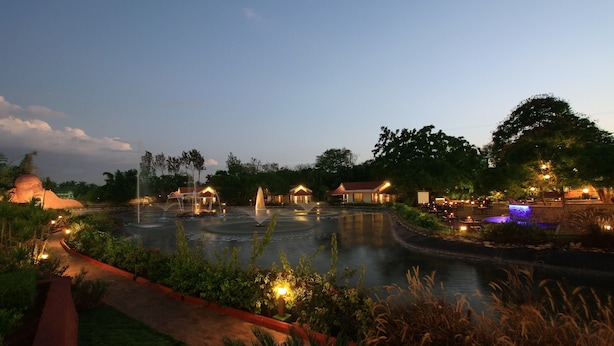 Un hotel tranquilo junto al río, con una fuente, caminos bien iluminados y abundante vegetación.