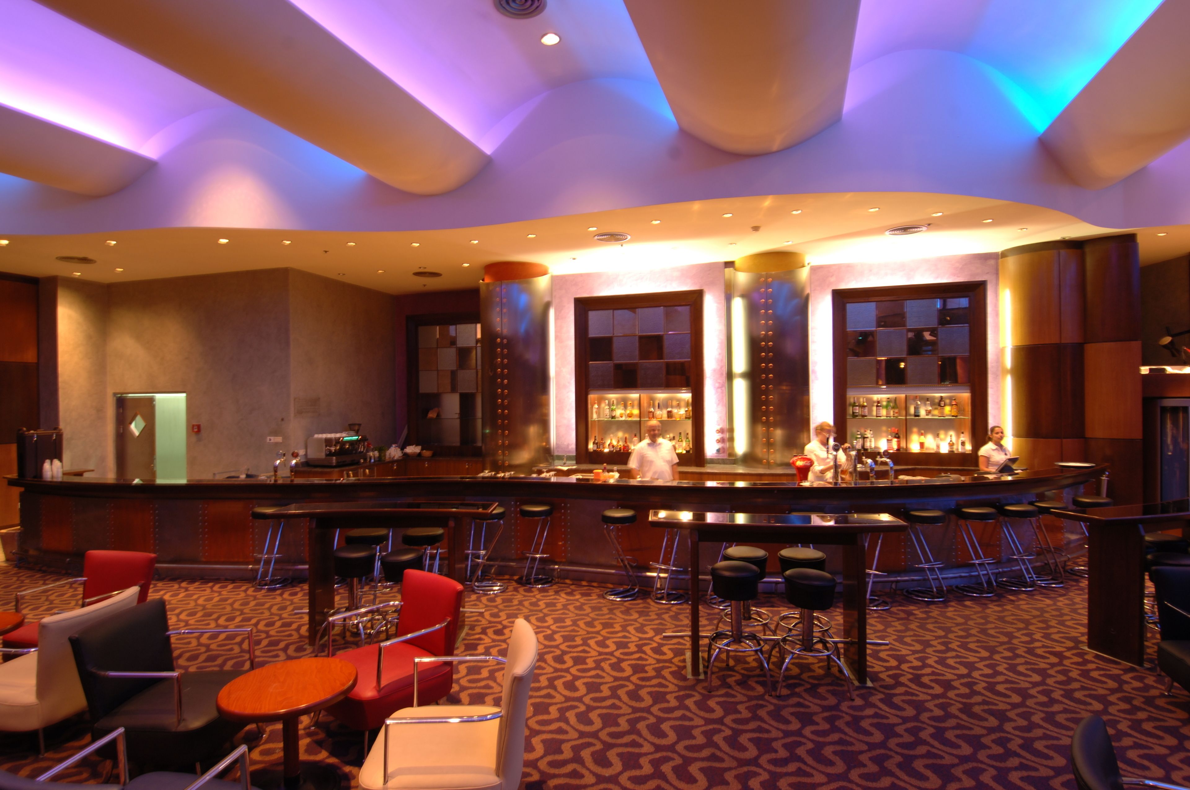 A bar area with multiple stools, a counter, and a barista.