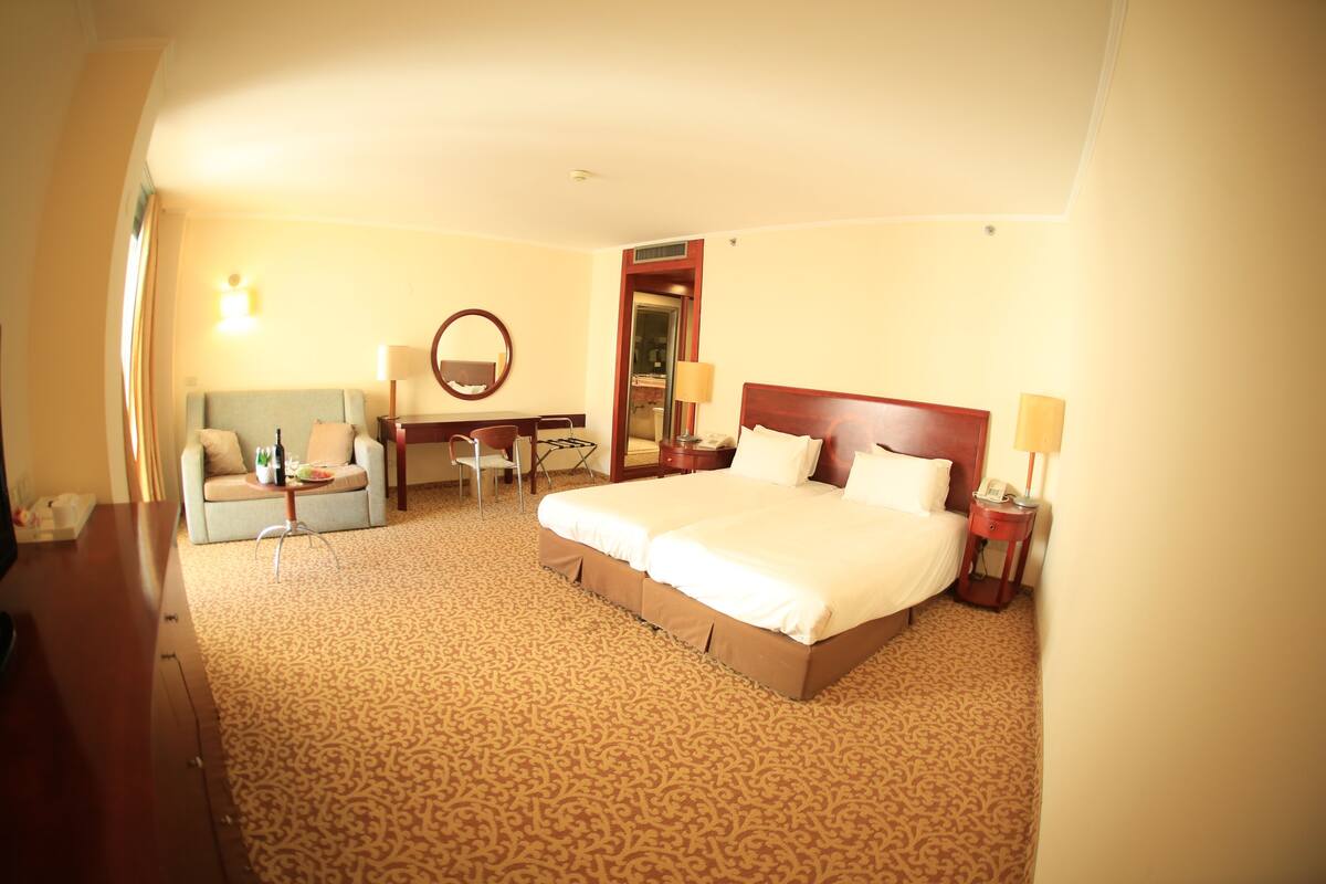 Een hotelkamer met een groot bed, een bureau, een stoel en een bank.