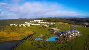 Experience serene surroundings and scenic views at this resort, set amidst lush greenery and a tranquil body of water.