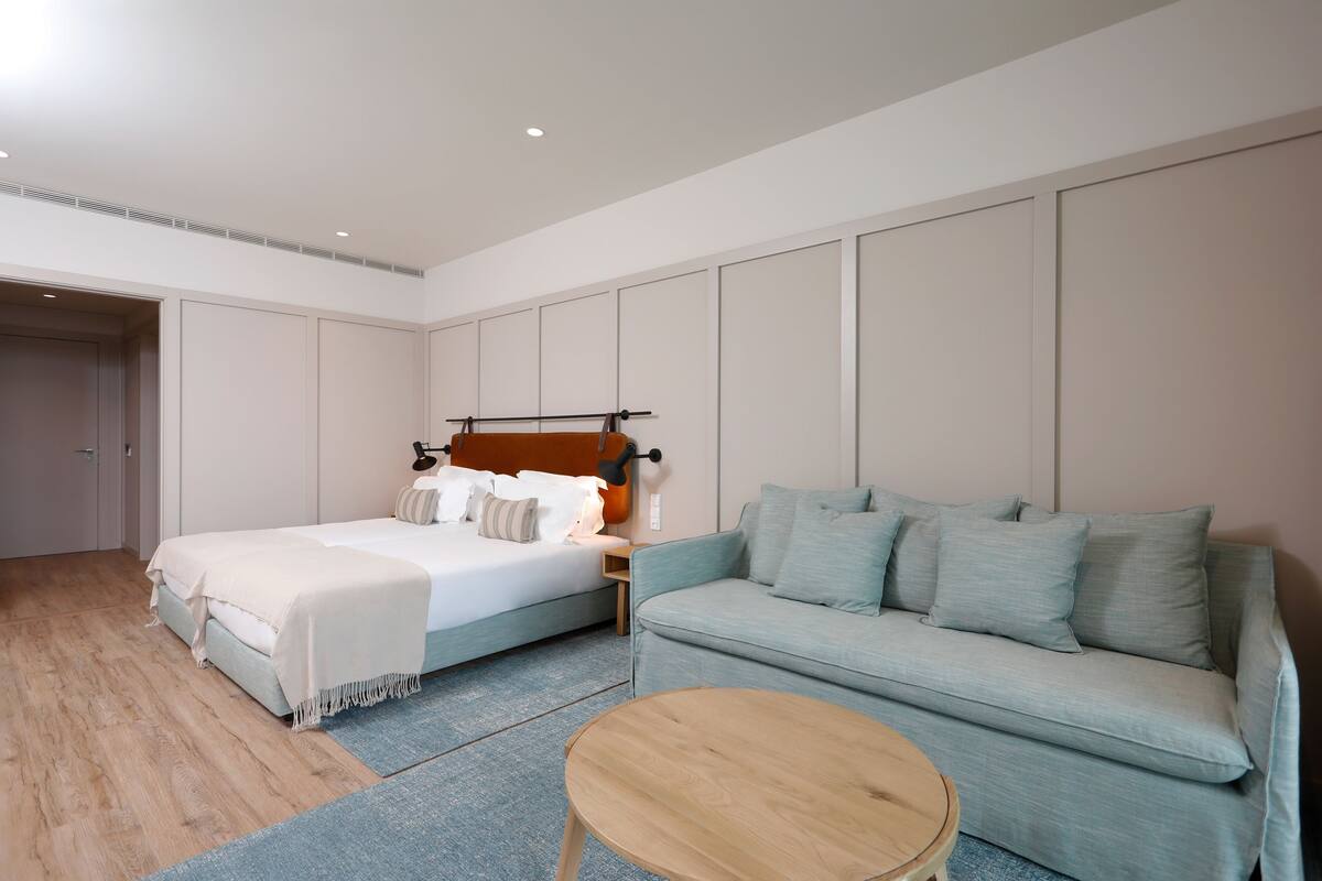 Ein Schlafzimmer mit einem Bett, einem Sofa und einem runden Tisch.