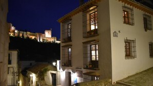 A building with barred windows, a stone staircase, and a sign indicating a restaurant. - Apartamentos Turísticos Alhambra (Granada)