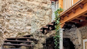 A stone staircase leading to a wooden balcony with a view of a rocky wall. - Apartamentos Turísticos Alhambra (Granada)