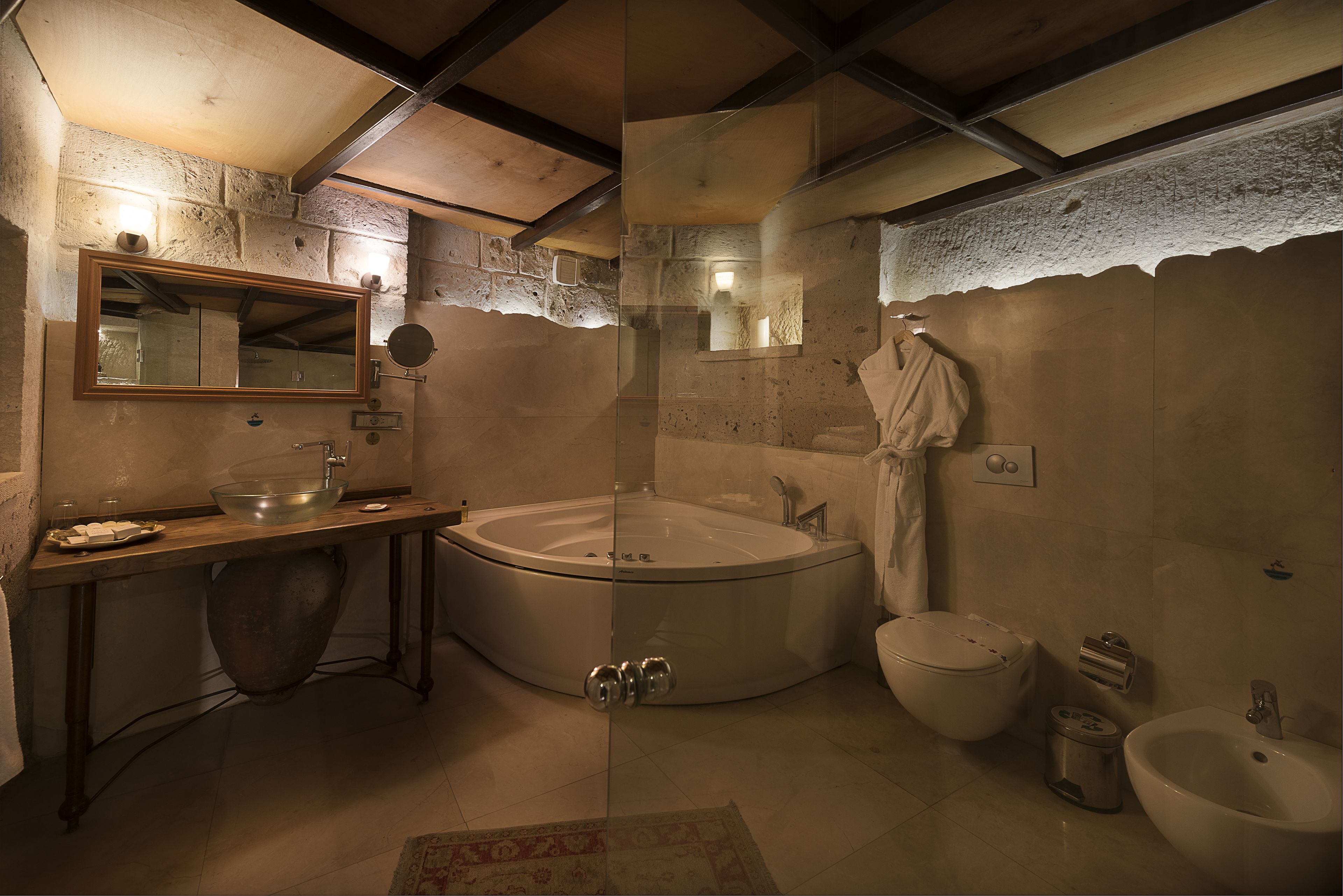 A bathroom with a large bathtub, a sink, a toilet, and a bidet.