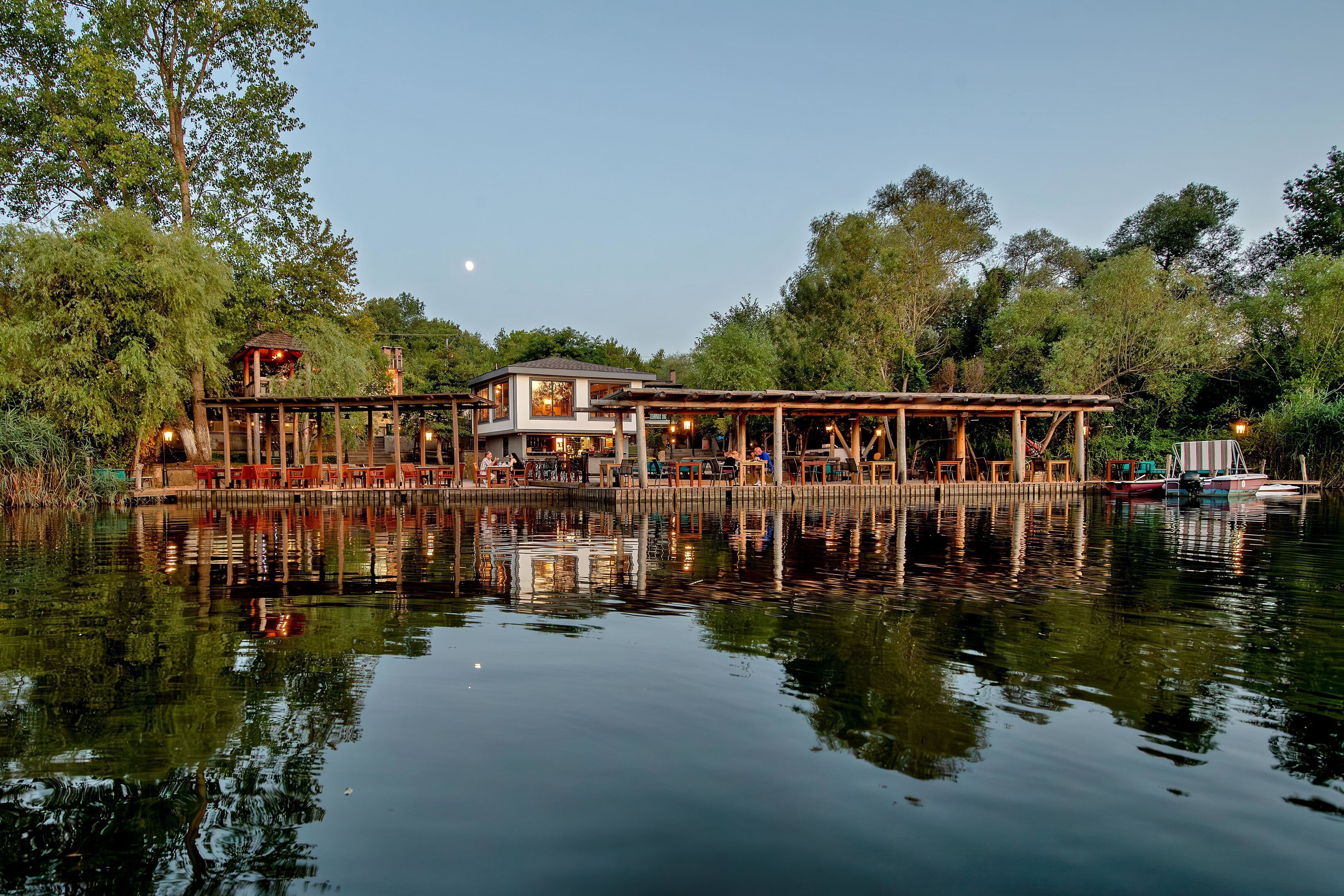 Un restaurante junto al lago con terraza y vistas al agua.