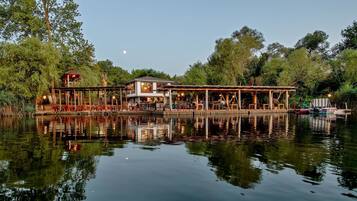 Un restaurant situé au bord du lac, avec une terrasse et vue sur l’eau.