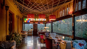 A cozy interior with a wooden ceiling, large windows, and comfortable seating. - Wineport Lodge Agva (Sile)