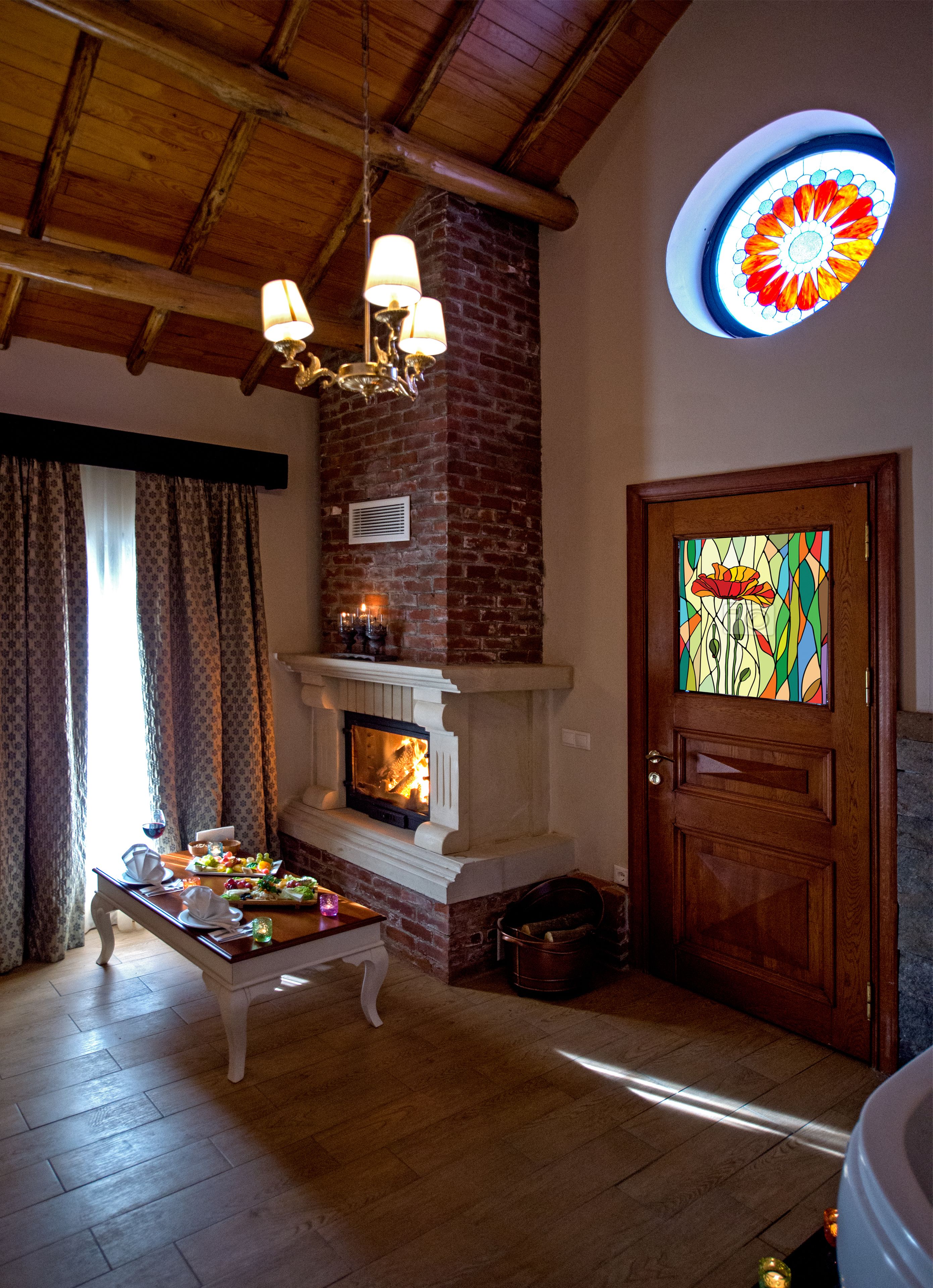 Une pièce chaleureuse avec une cheminée, un plafond en bois et une porte en vitrail.