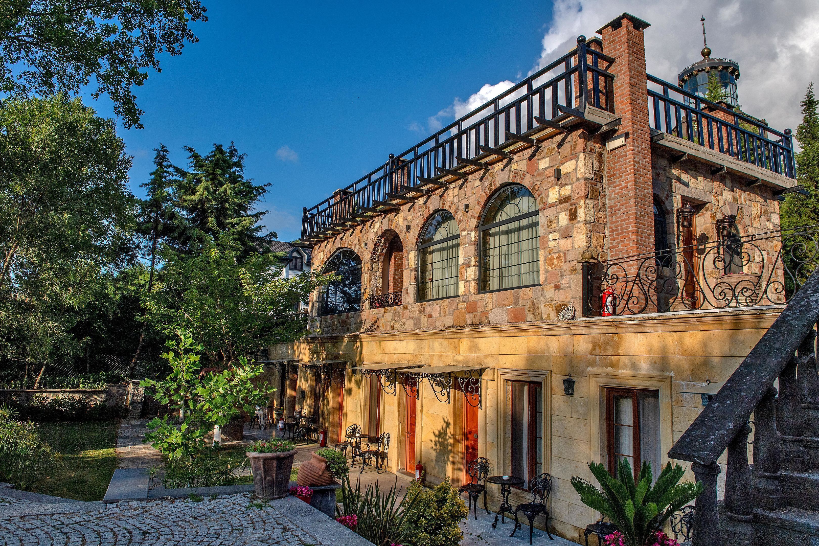 Un edificio histórico con balcón, ventanas arqueadas y fachada de piedra.