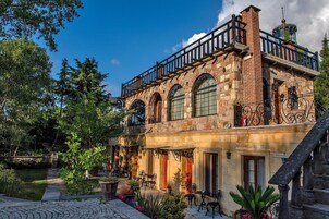 A historic building with a balcony, arched windows, and a stone facade.