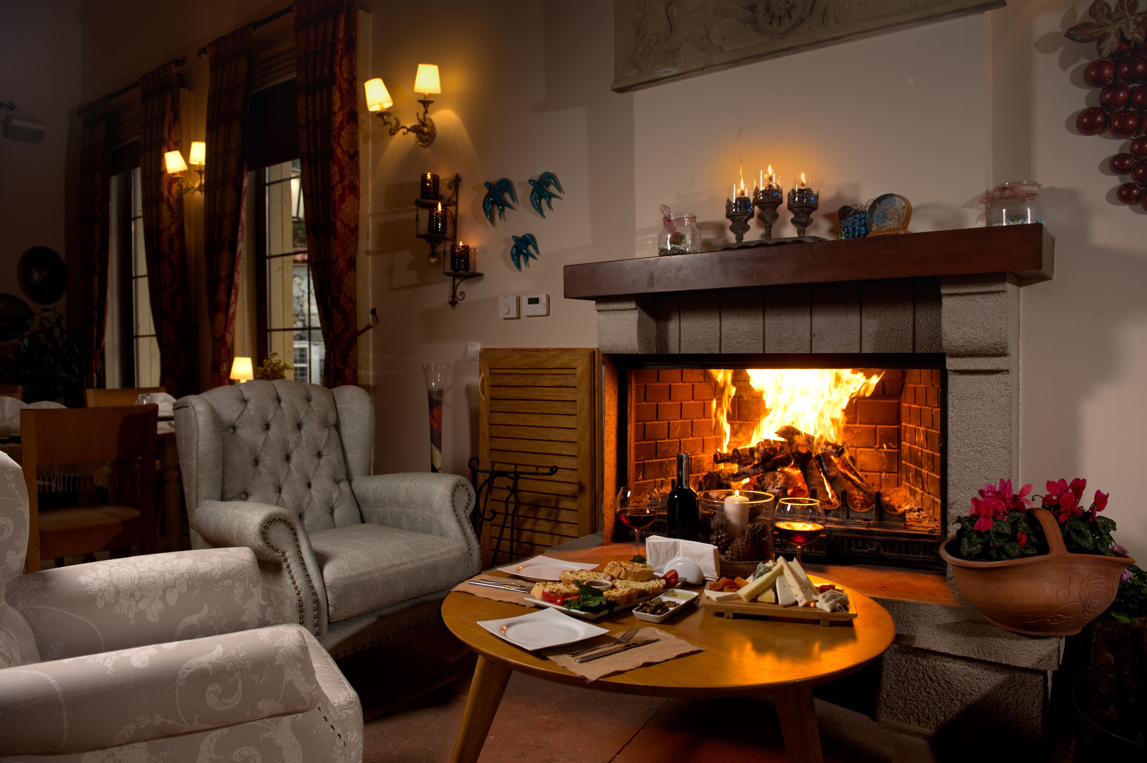 Una sala de estar acogedora con chimenea, asientos cómodos y una mesa de comedor preparada para una comida.