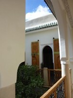 A courtyard with a traditional tiled roof, wooden doors, and a small garden area.