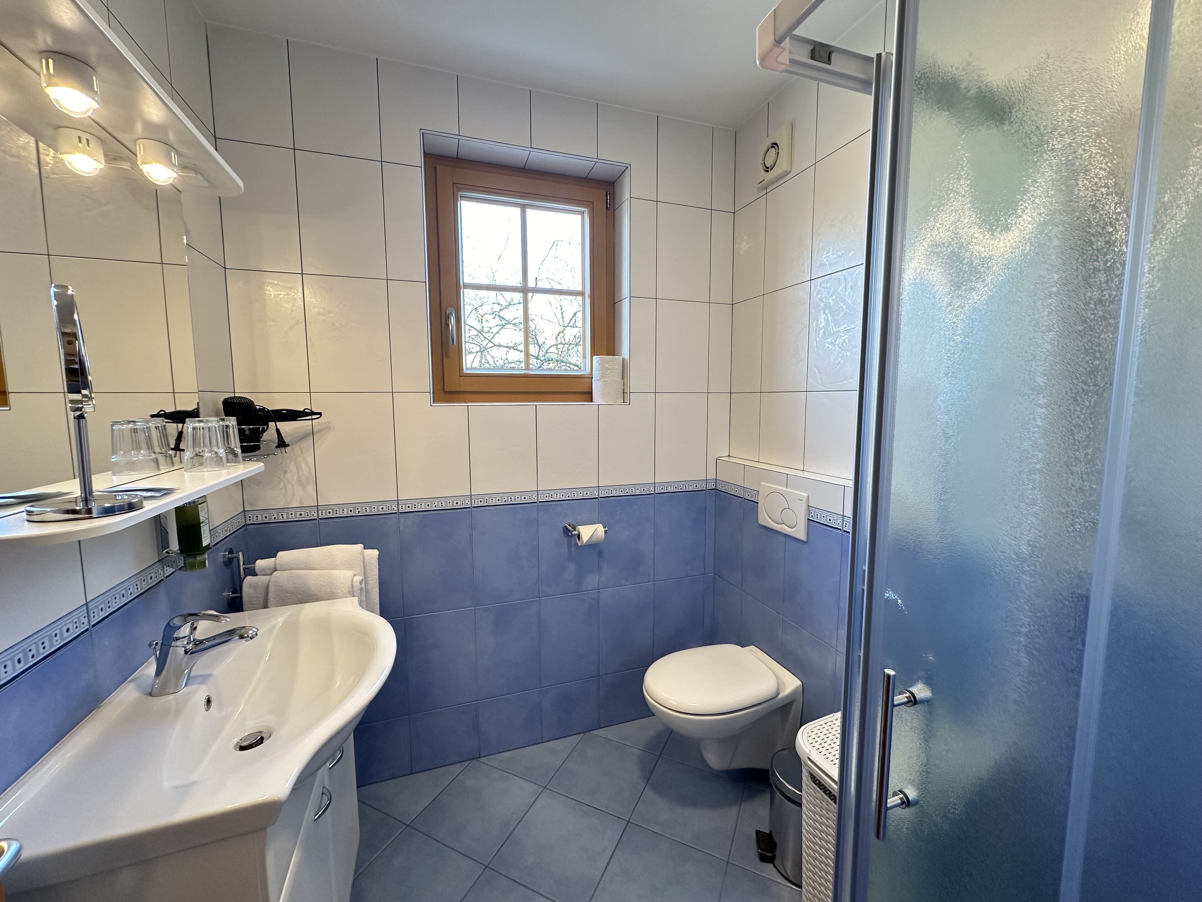 A bathroom with a white sink, a toilet, and a shower area.
