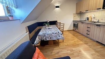 Una cocina acogedora con comedor, armarios de madera y horno empotrado.