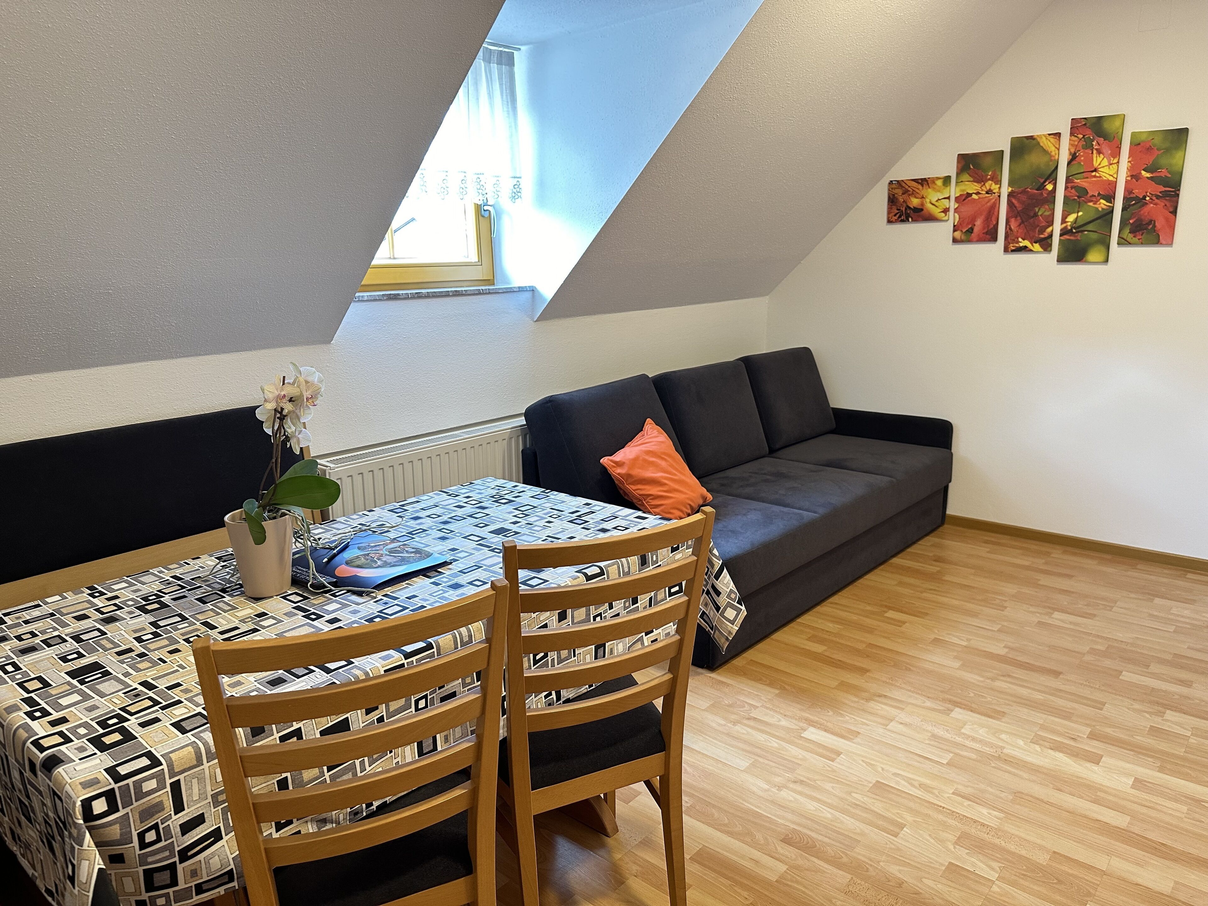 Ein gemütliches Lofts mit Essbereich, einer Couch und einer Wand mit Kunstwerken.