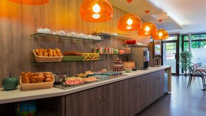 A breakfast buffet with various food items and a coffee machine. - Reims Hotel (Paris)