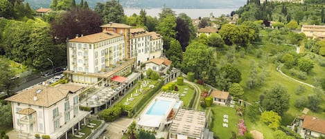 Een buitenzwembad, parasols bij het zwembad en ligstoelen