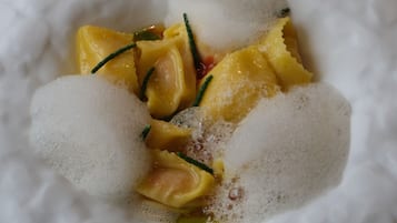 A white plate with a dessert consisting of yellow fruit pieces and sugar.