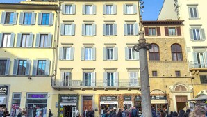 A bustling urban square with historic buildings, a central fountain, and various storefronts including a restaurant and a bar. - Duomo View B&B (Florence)