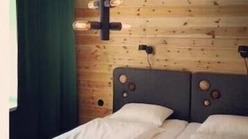 Habitación doble | Tabla de planchar con plancha y ropa de cama