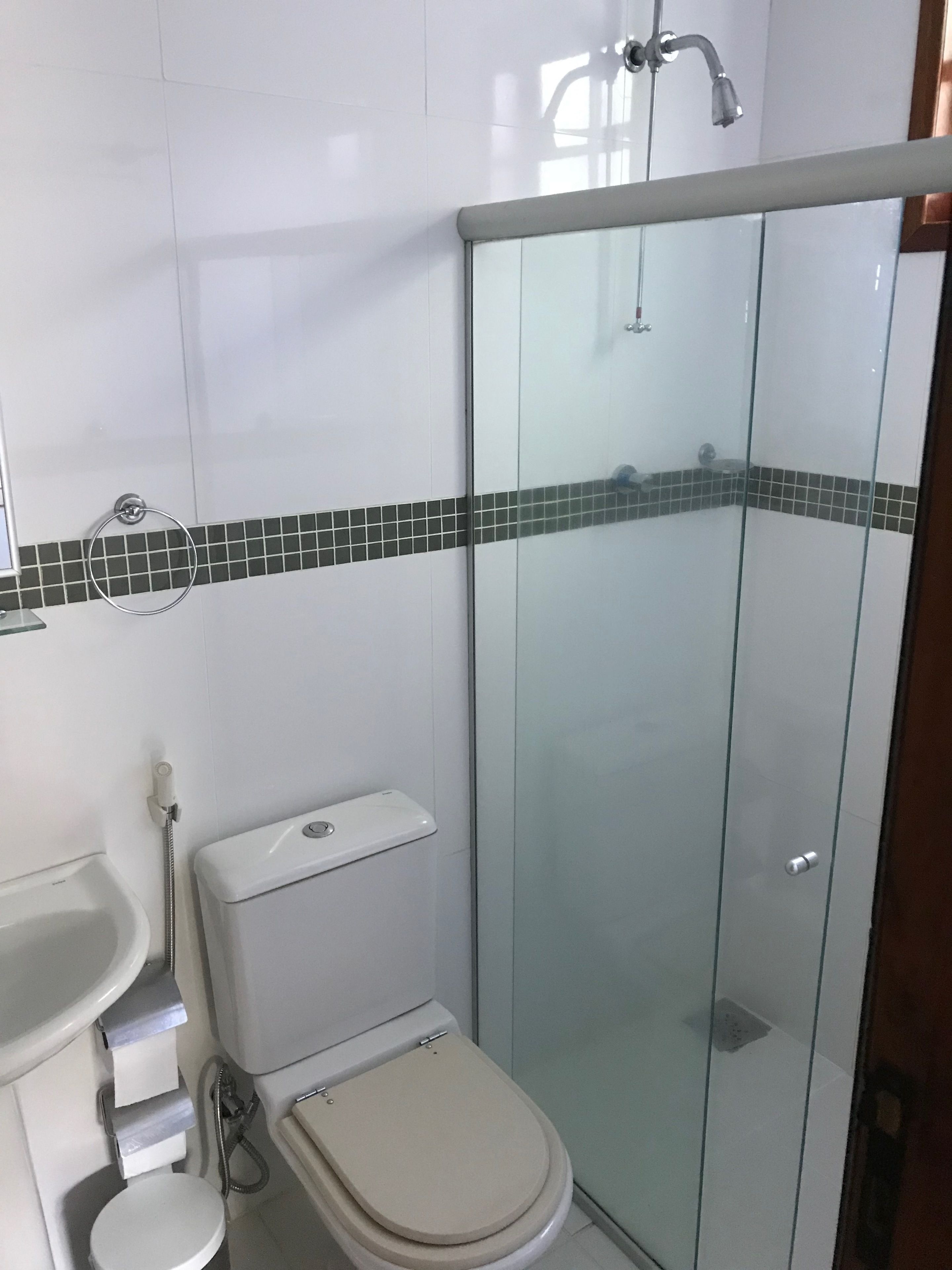 A modern bathroom with a glass shower enclosure, a toilet, and a sink.