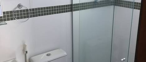 A modern bathroom with a glass shower enclosure, a toilet, and a sink.