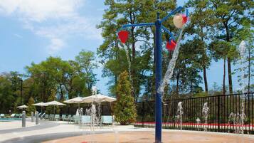 Una piscina al aire libre, sombrillas, sillones reclinables de piscina