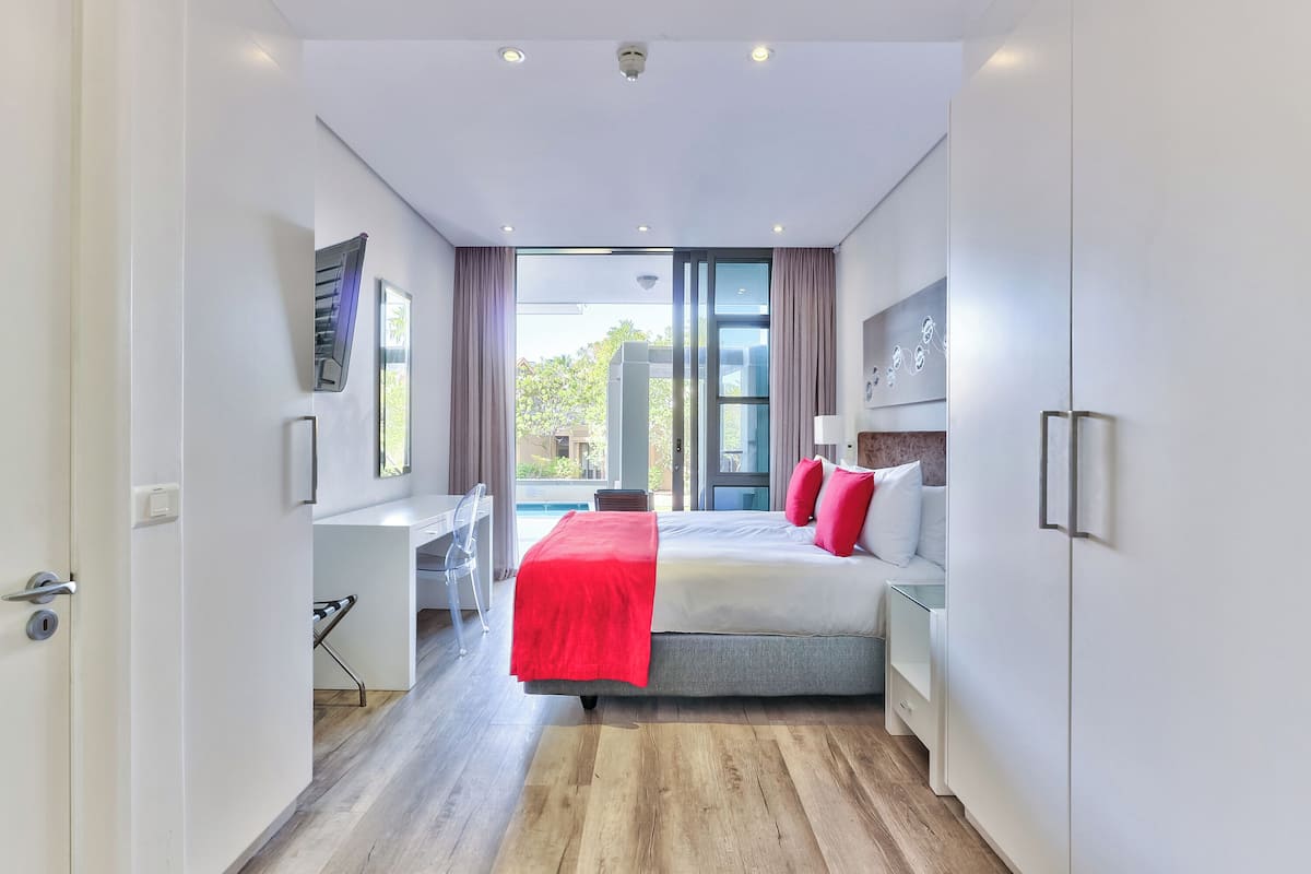 Een moderne hotelkamer met een groot bed, een bureau en uitzicht op de omgeving.