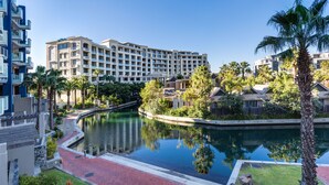 Un hotel con una piscina grande, palmeras y un cielo azul despejado.
