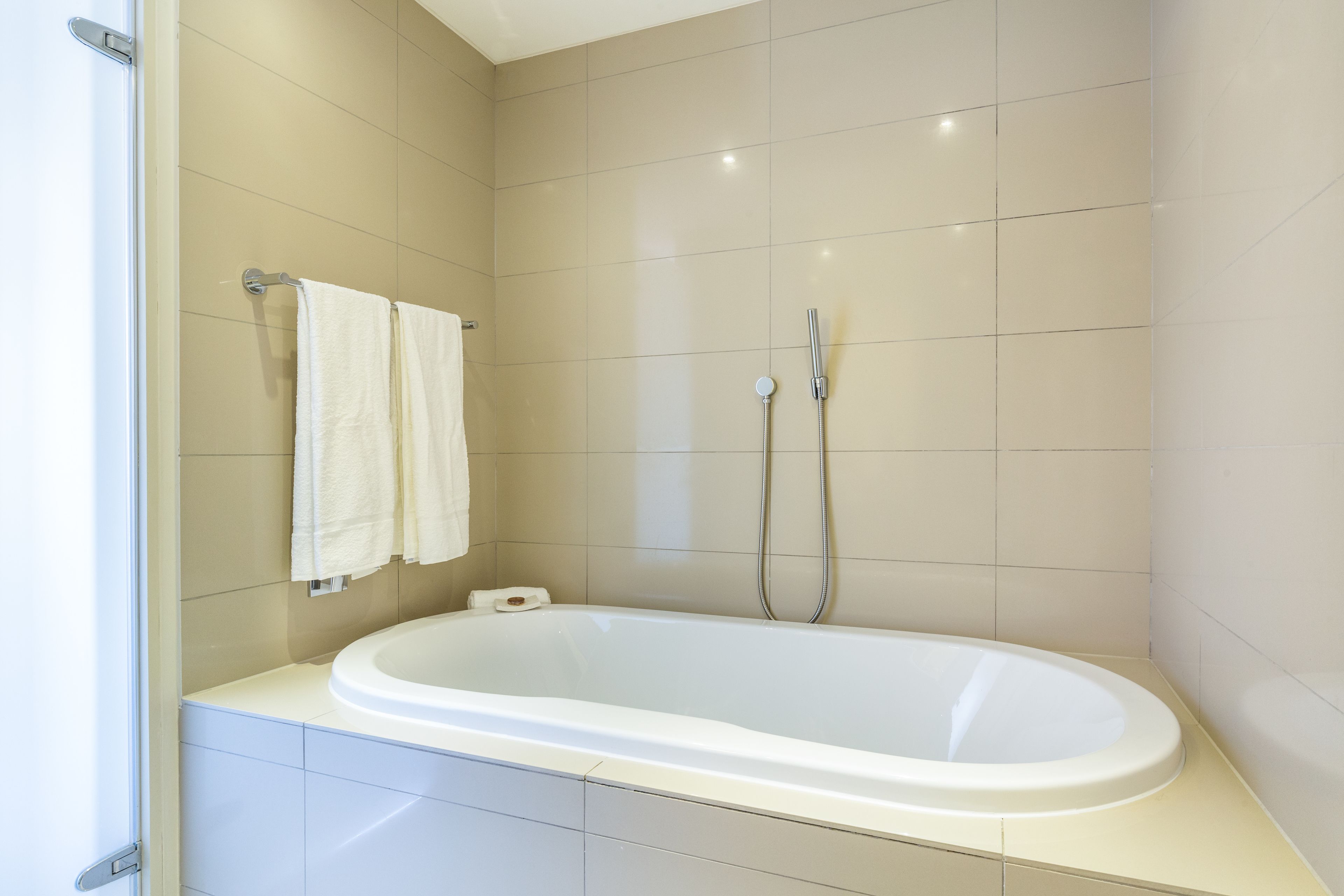 Ein modernes Badezimmer mit einer Badewanne, einer Dusche und einem WC.