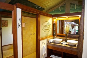 A bathroom with a wooden vanity, two sinks, a mirror, and a shower area. - Samburu Intrepids Tented Camp (Samburu)