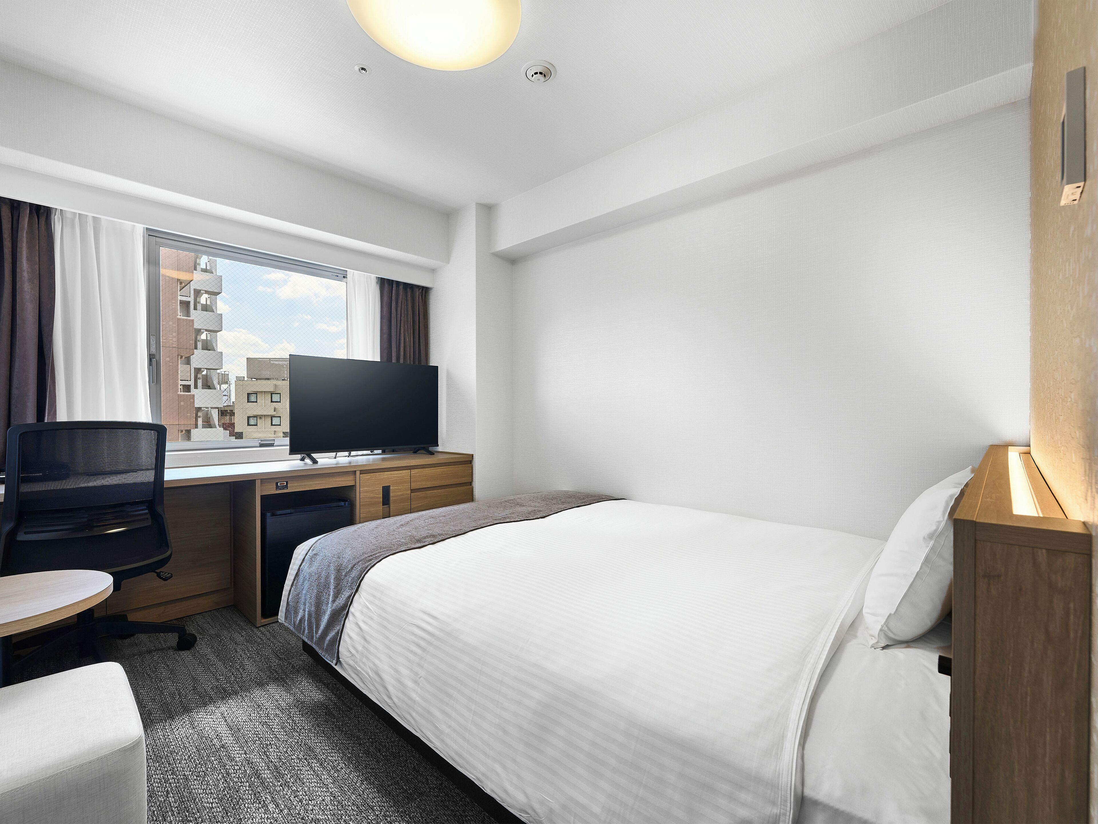 Ylelliset vuodevaatteet, untuvapeitot, tallelokero huoneessa