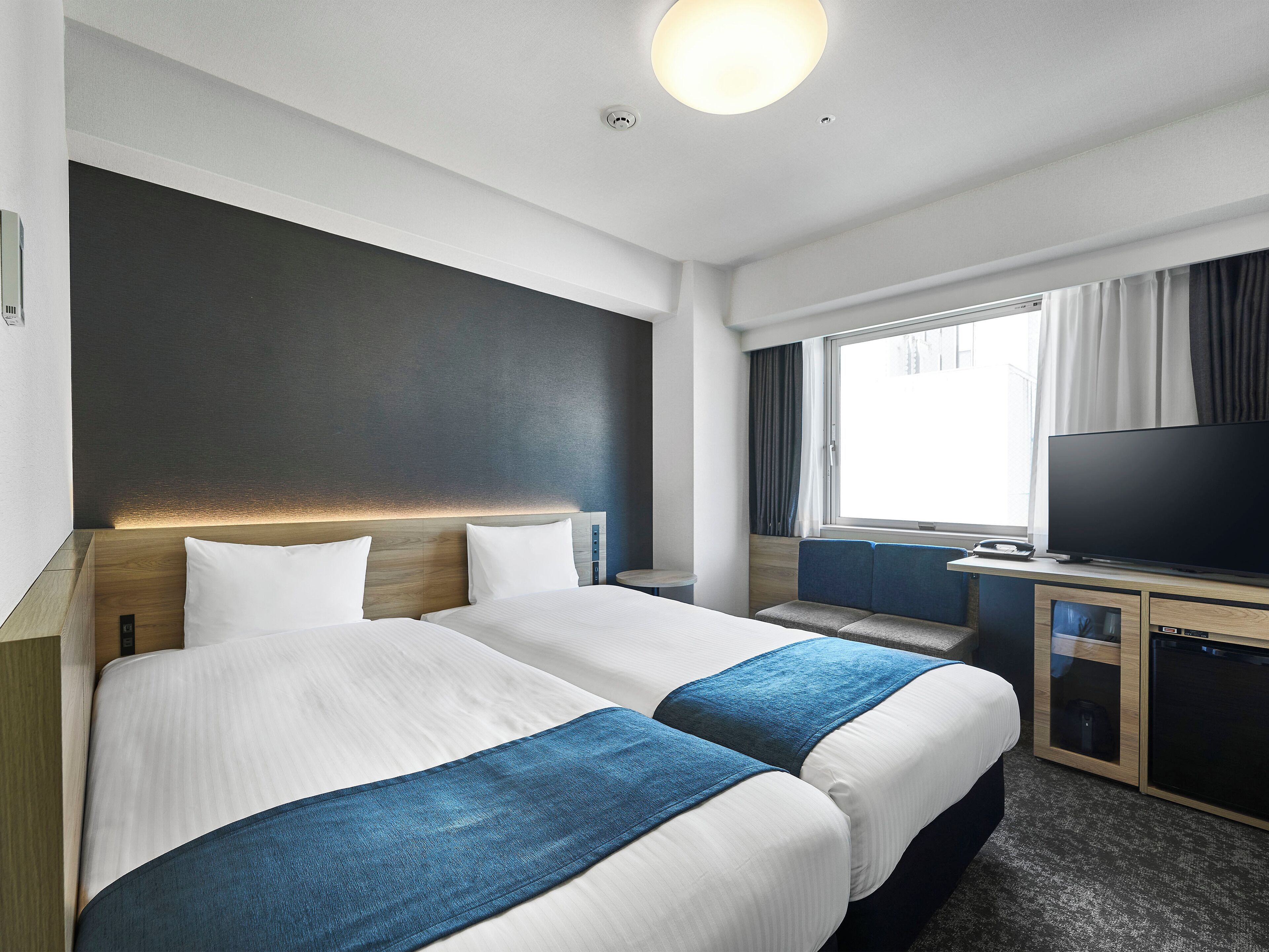 Ylelliset vuodevaatteet, untuvapeitot, tallelokero huoneessa