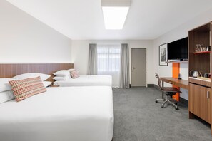 A hotel room with two beds, a desk, a chair, a television, and a wardrobe. - JetPark Hotel Hamilton Airport (Ohaupo)