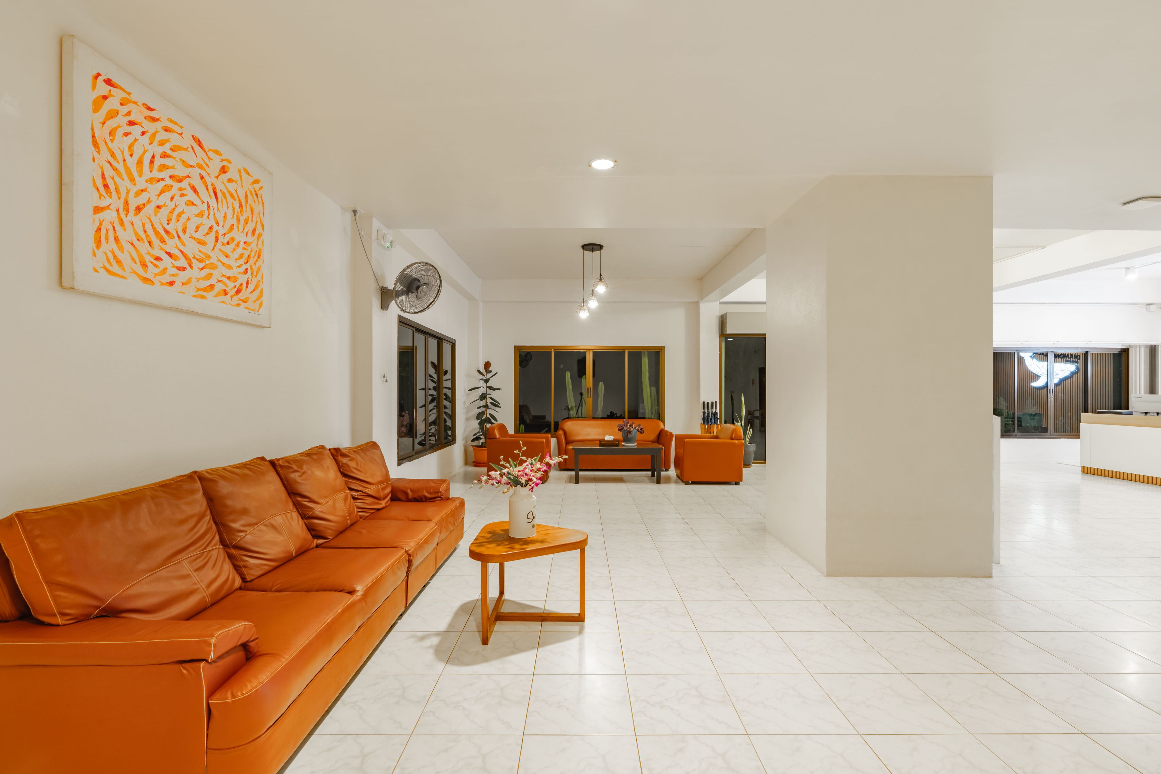 A modern living room with a leather sofa, a coffee table, and a large painting on the wall.