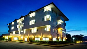 Ein mehrstöckiges Hotel mit beleuchteten Fenstern und einem gut ausgeleuchteten Eingang.