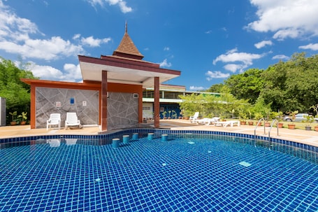 Una piscina al aire libre, sillones reclinables de piscina