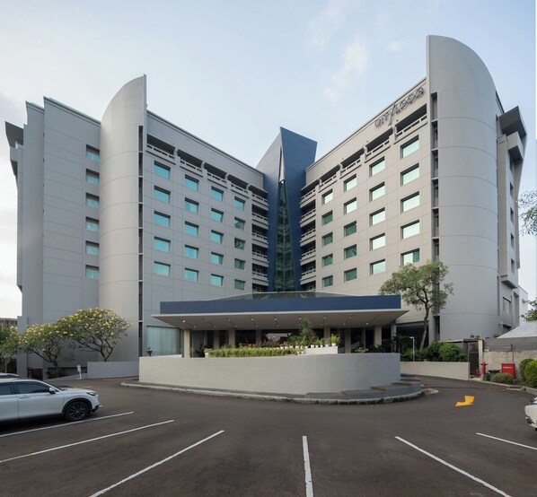A modern hotel with a central atrium, multiple floors, and a parking lot. - Cityloog Hotel Tebet Jakarta (Jakarta)