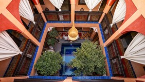 A courtyard with a central pool, surrounded by balconies with ornate railings and white drapes. - Riad Alaka (Marrakech)