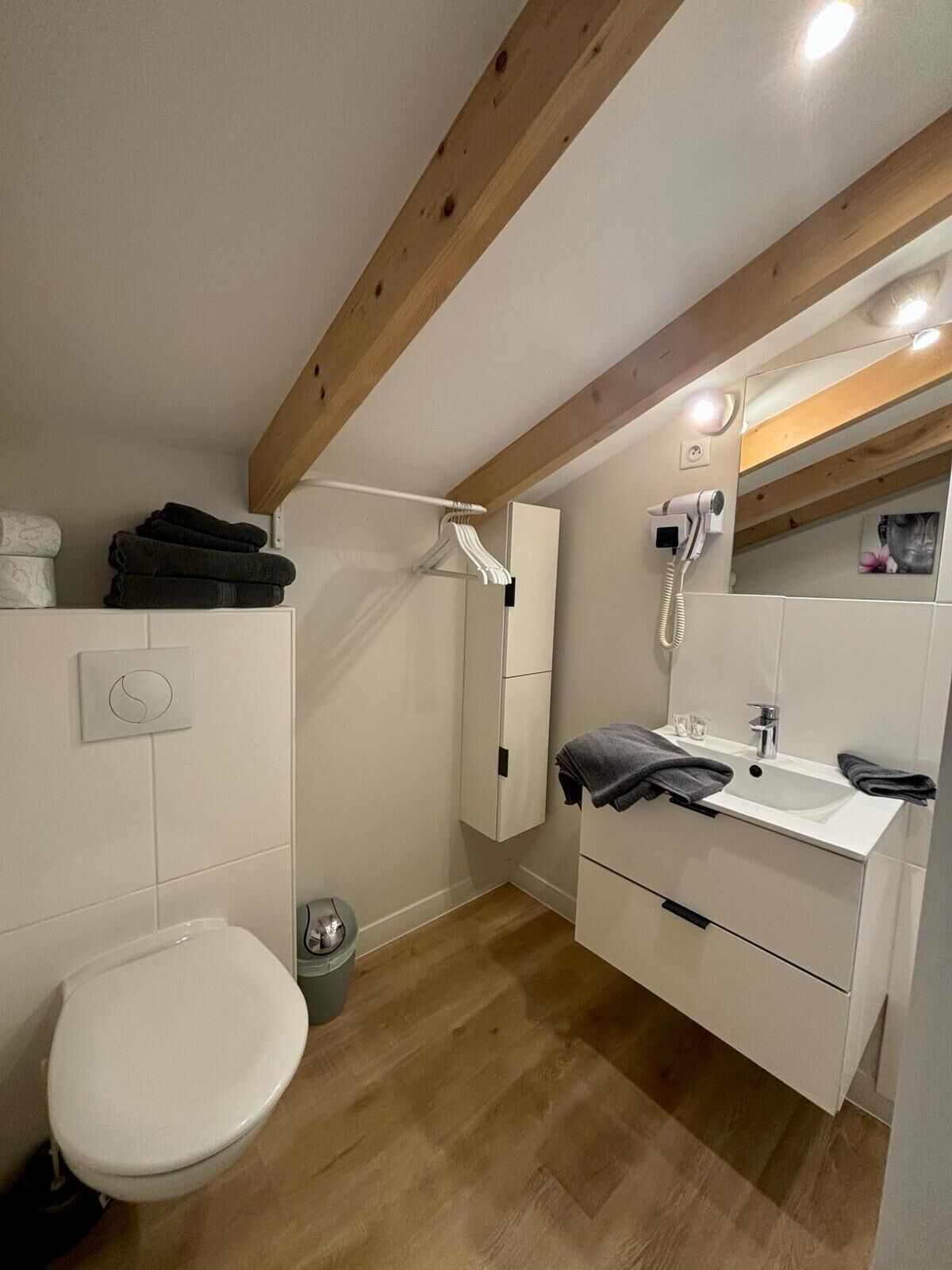 Een moderne badkamer met toilet, wastafel en douche.