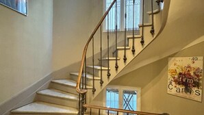A staircase with a wooden handrail and a black and white patterned floor. - Rent Cannes Meublés Gambetta (Cannes)