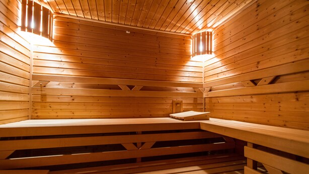 Un sauna avec des bancs en bois et un plancher à lattes.