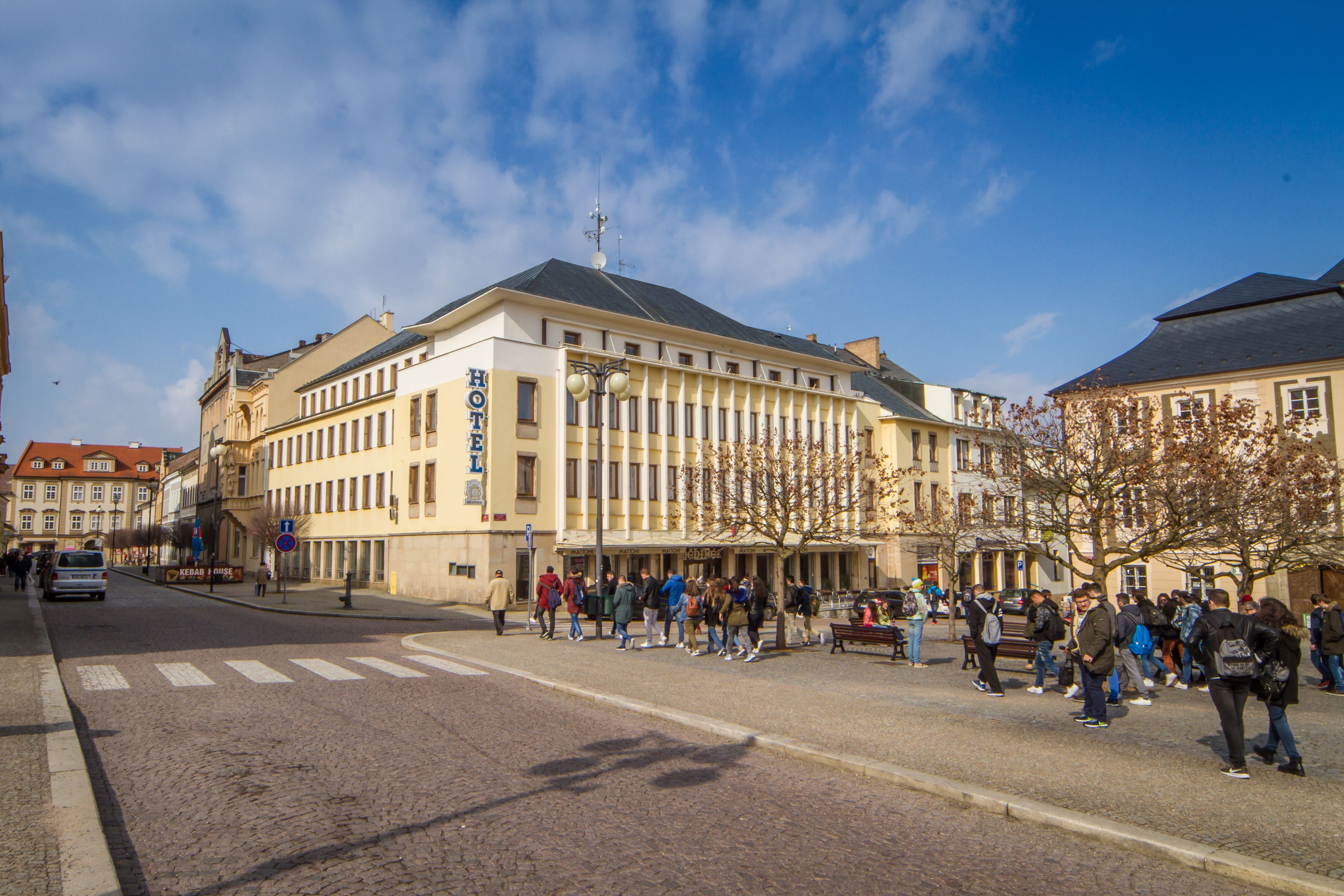 Ett hotell med en klassisk europeisk arkitektur, kännetecknat av en imponerande entré och en rad fönster längs fasaden.