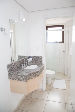 A bathroom with a granite countertop sink, a mirror, a towel rack, and a toilet. - Plaza Inn Trevo Sorocaba (Sorocaba)