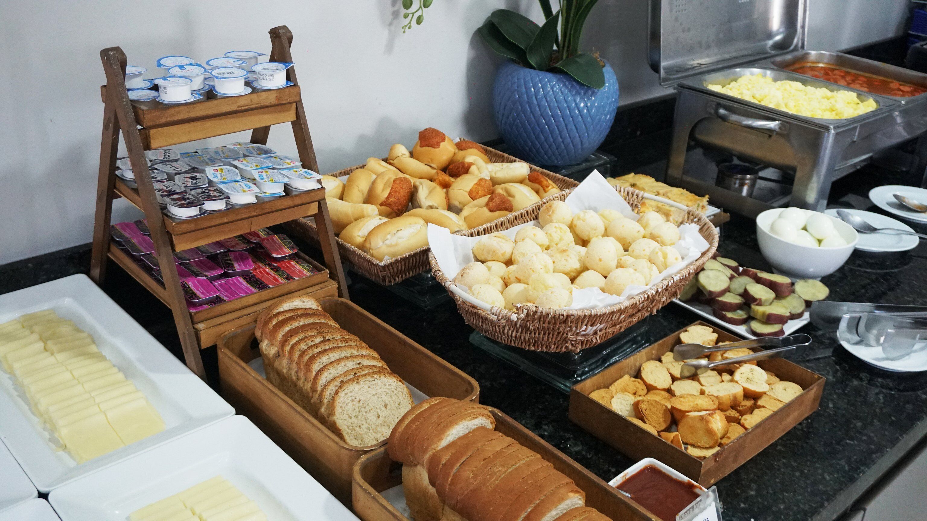 A buffet with various food items including bread, pastries, and condiments.